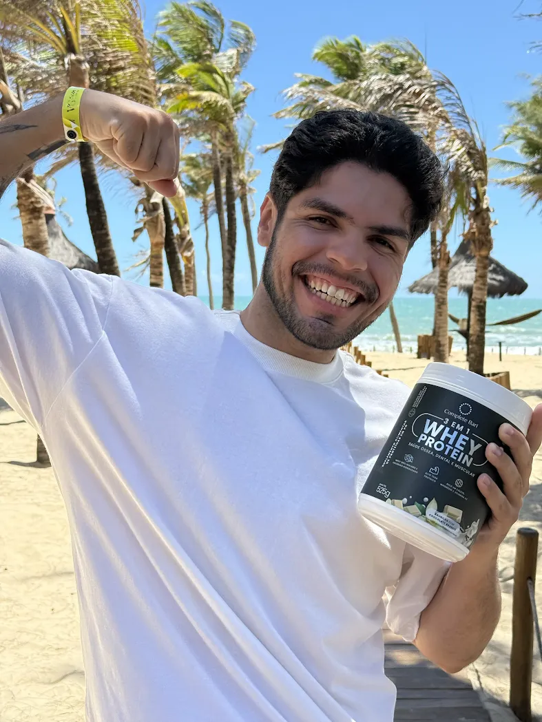 Homem sorrindo com Whey Protein Complete Bari na praia